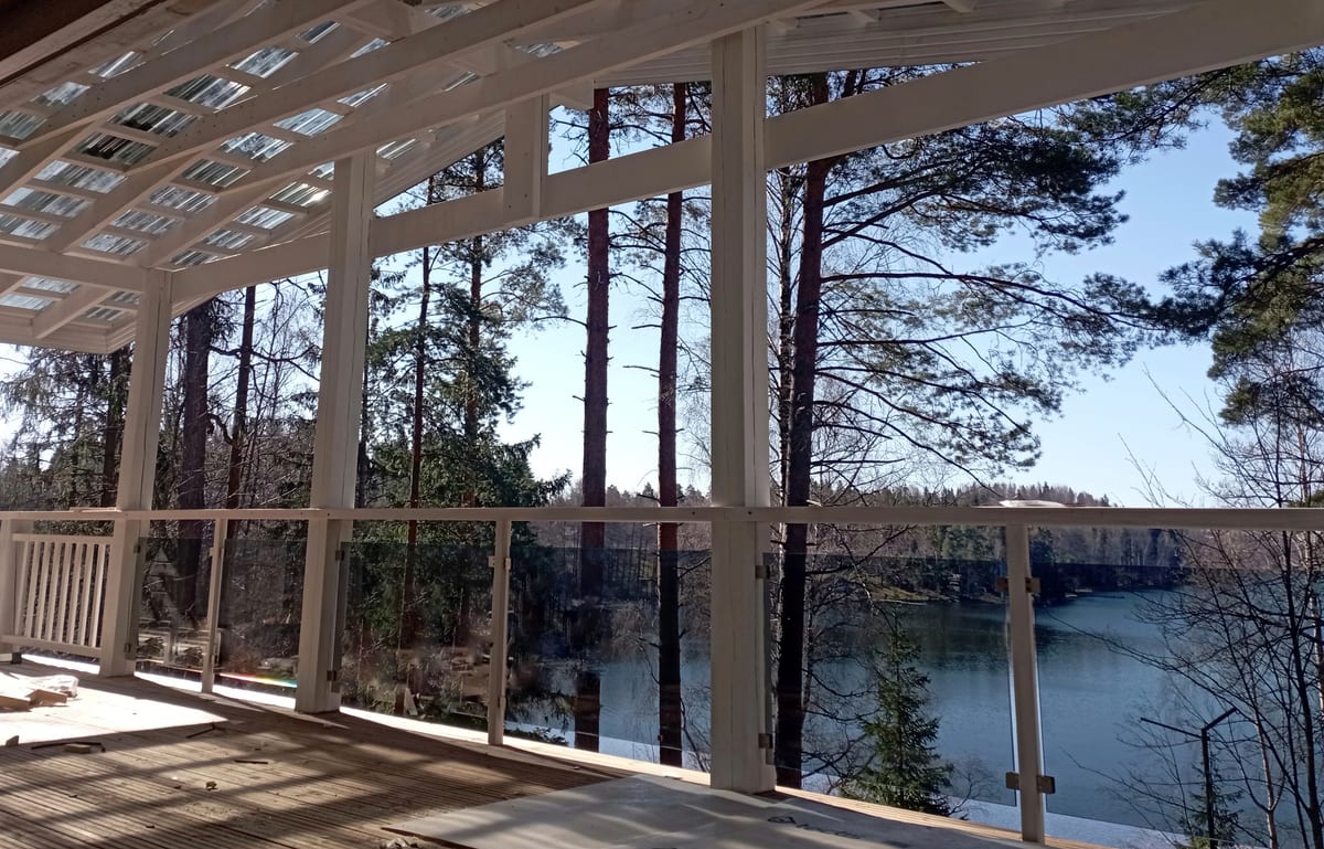 Näkymä katetulta terassilta männikön läpi järvelle
