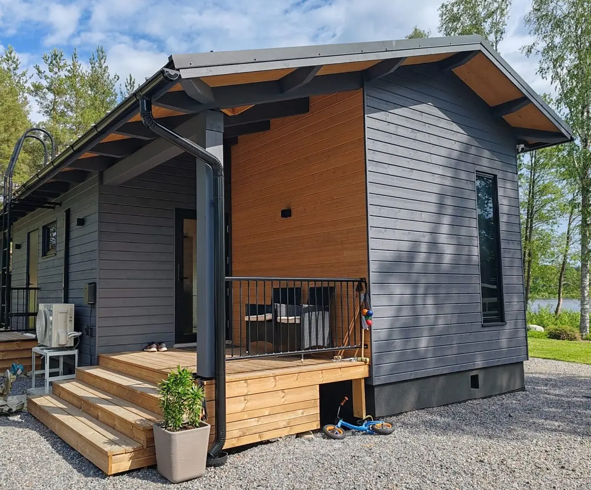 Loma-asunnon kuisti ja portaat, järvi taustalla kesäpäivänä