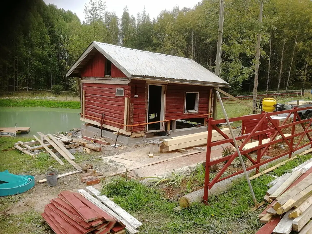 Hirsisauna peruskorjattavana lammen rannalla, uudet hirret ja tunkit paikoillaan